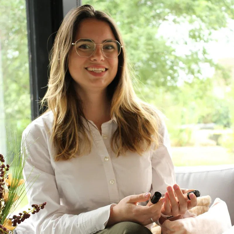 La fondatrice qui sourit avec les roll'ons dans les mains