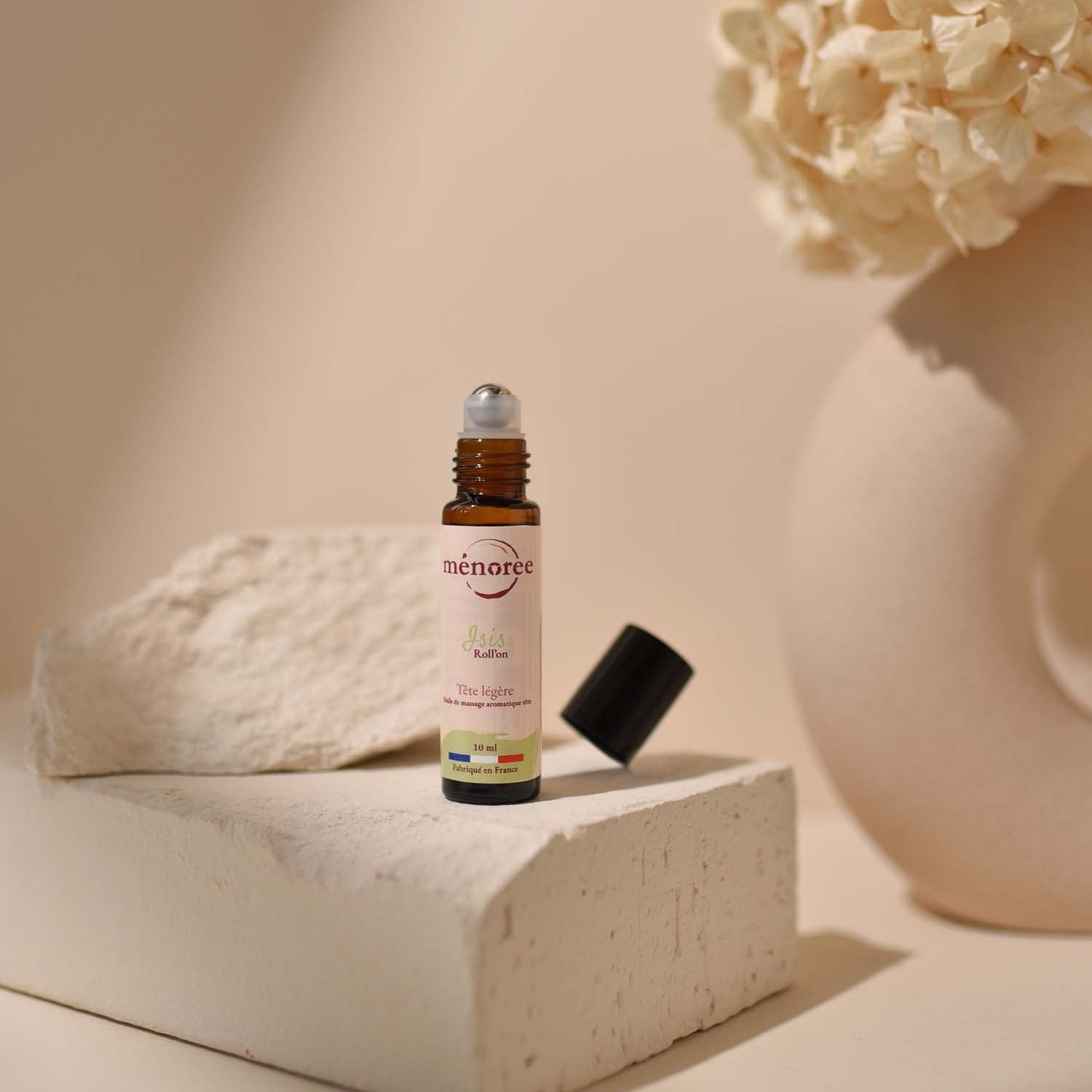 Roll on Isis ouvert sur une pierre avec un bouquet de fleur